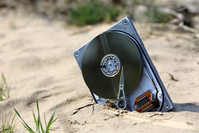 lost computer data storage, hard drive, on sand in outdoors