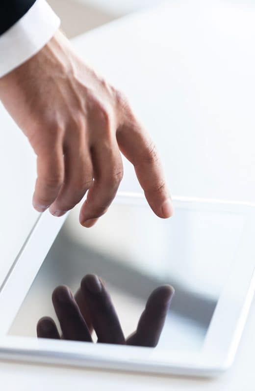 Join a digital age! Top view of human hand touching a screen of digital tablet laying on the table