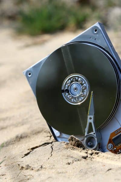 lost computer data storage, hard drive, on sand in outdoors